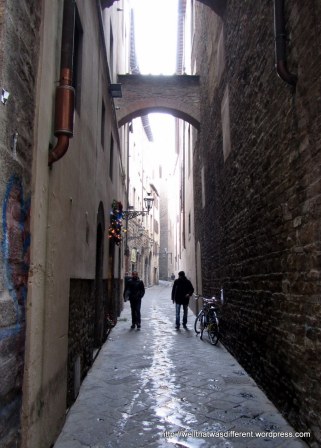 Just an alley with black-clad Florentines and a bike.